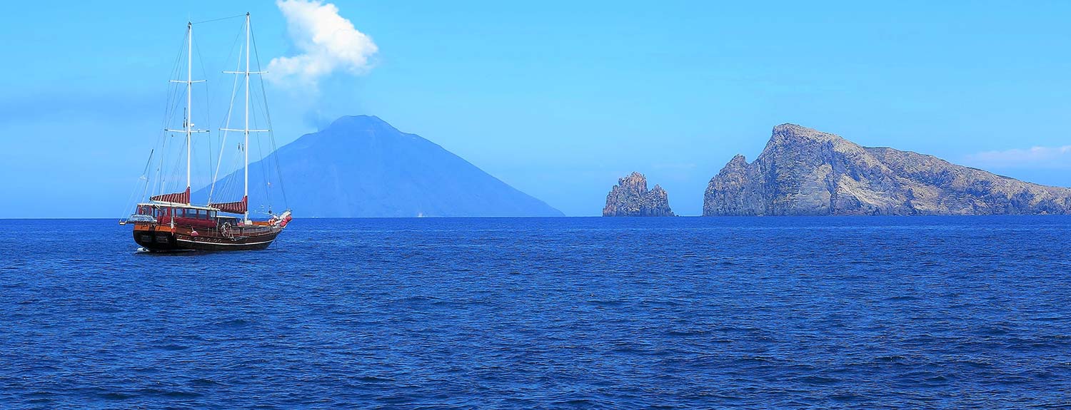 boat sailing on sea beside an active volcano