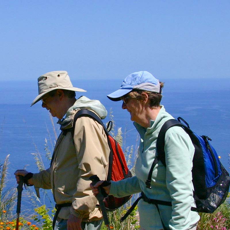 Couple hiking overlooking the sea in Sicily